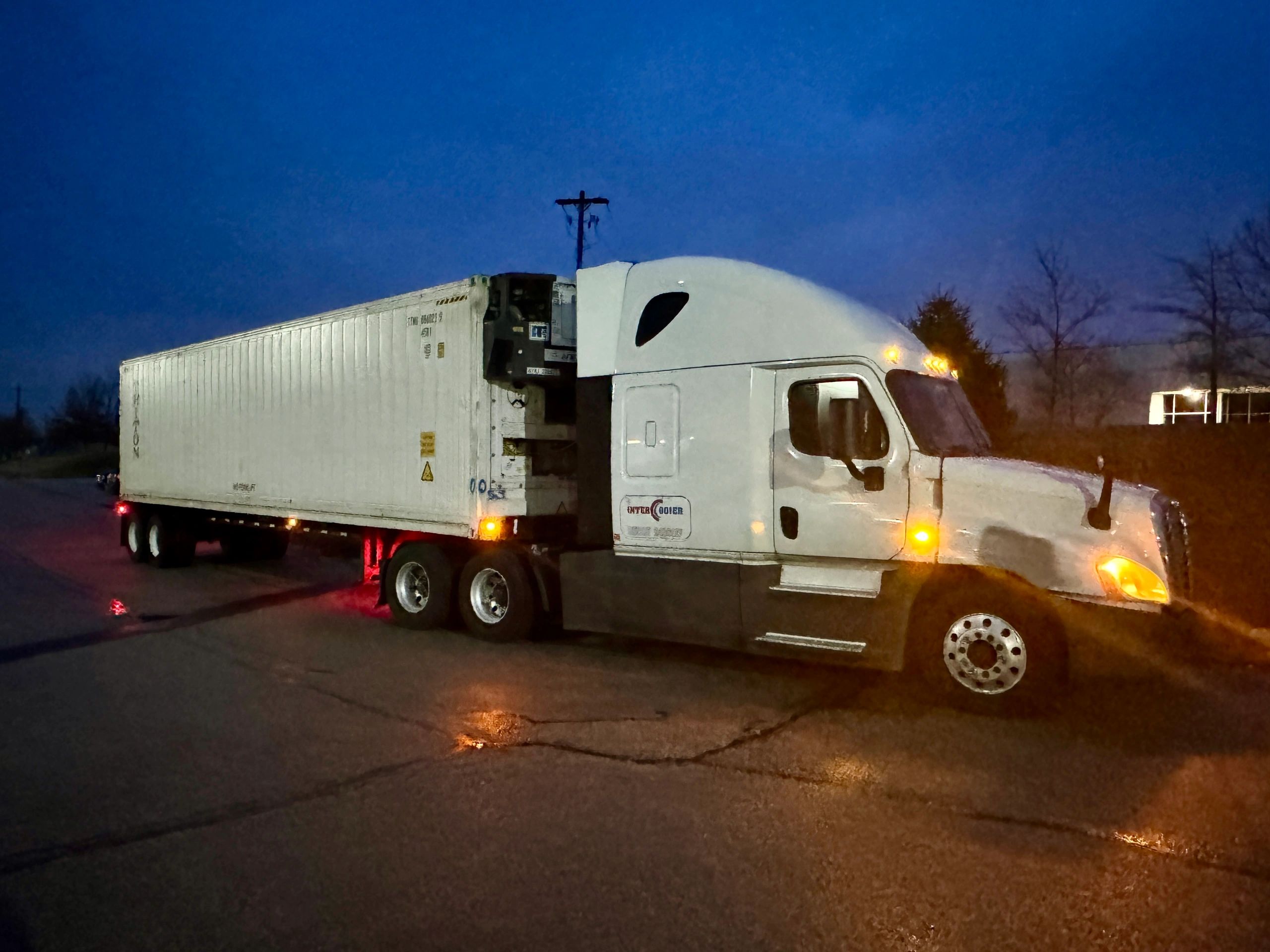 White refrigerated semi-truck at night