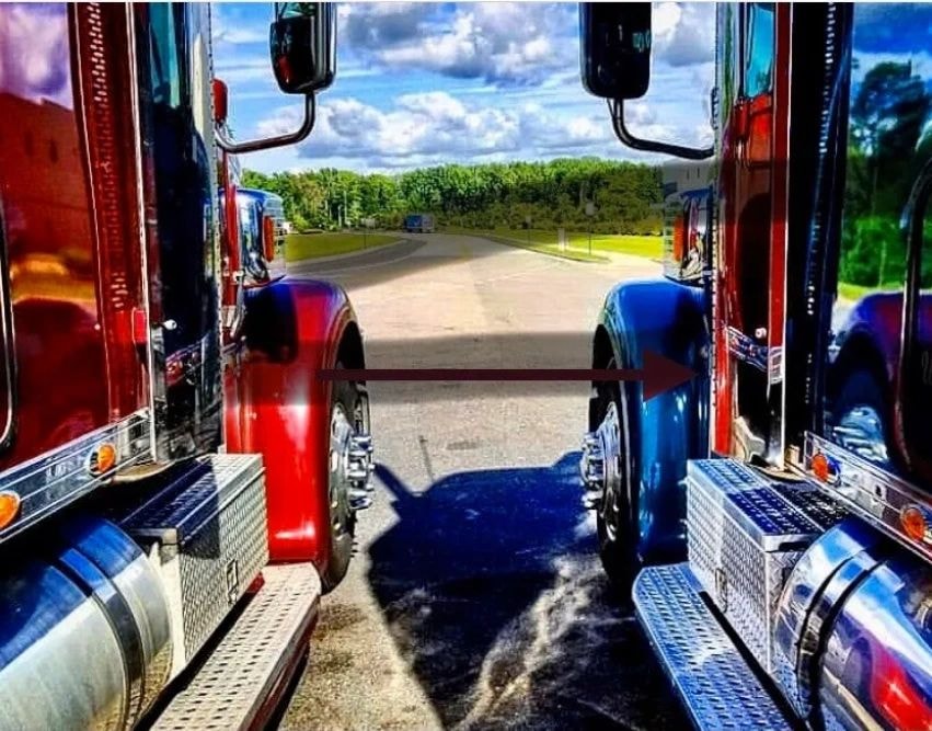 View between two trucks with highway landscape